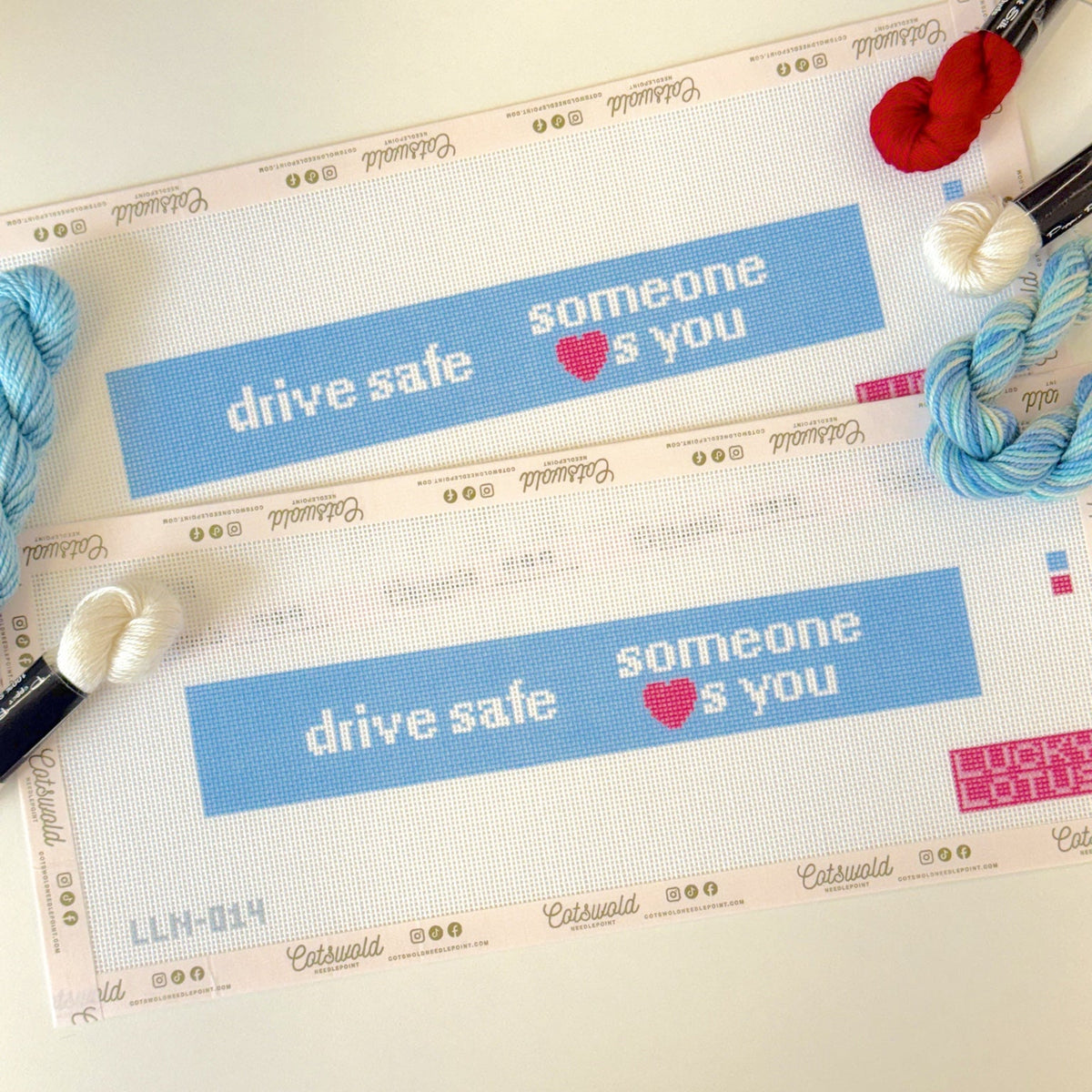Close-up of Drive Safe Someone Loves You needlepoint canvas showing blue background and pink heart details