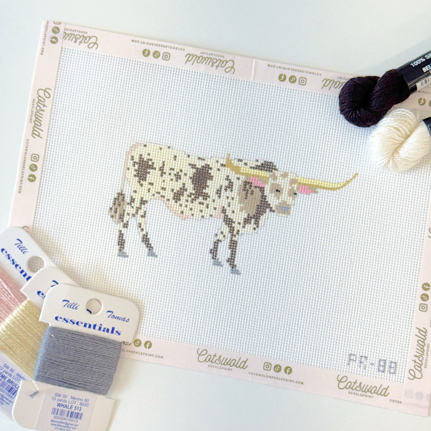 Texas longhorn cow needlepoint canvas styled flat lay with coordinating specialty fibers
