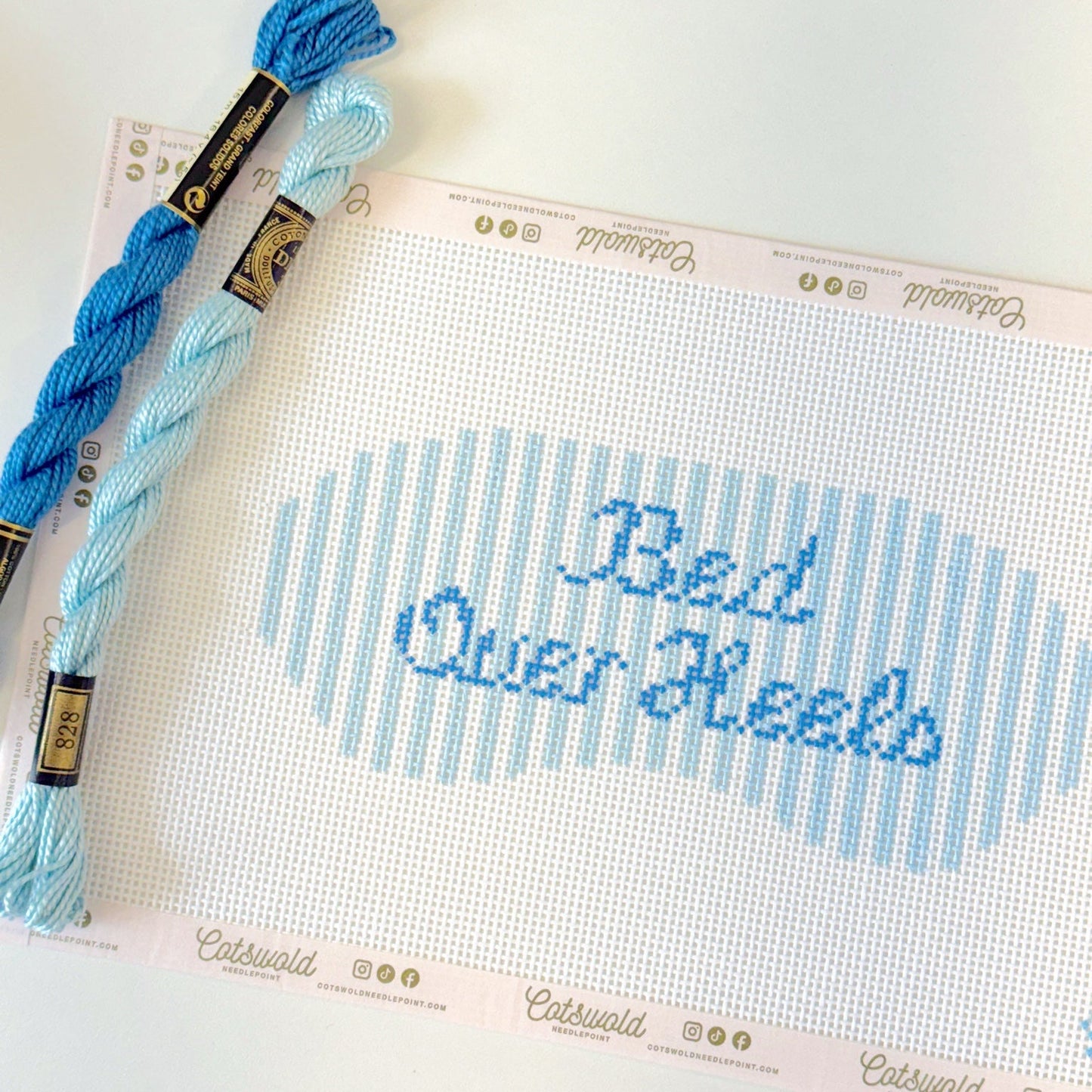 Close-up of Bed Over Heels blue phrase needlepoint canvas showing 13 mesh painted details