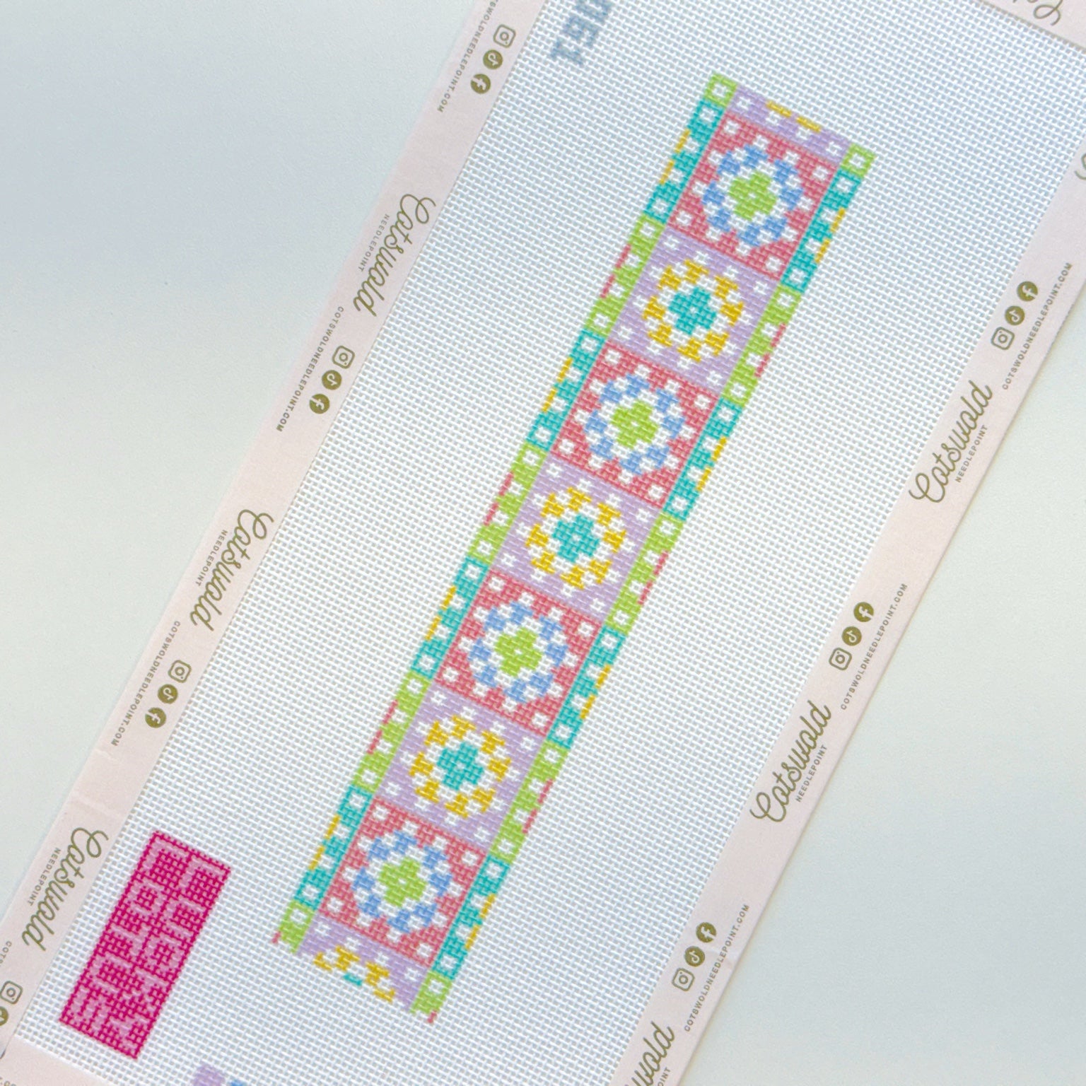 Angled view of pastel geometric needlepoint canvas strip on 18 mesh