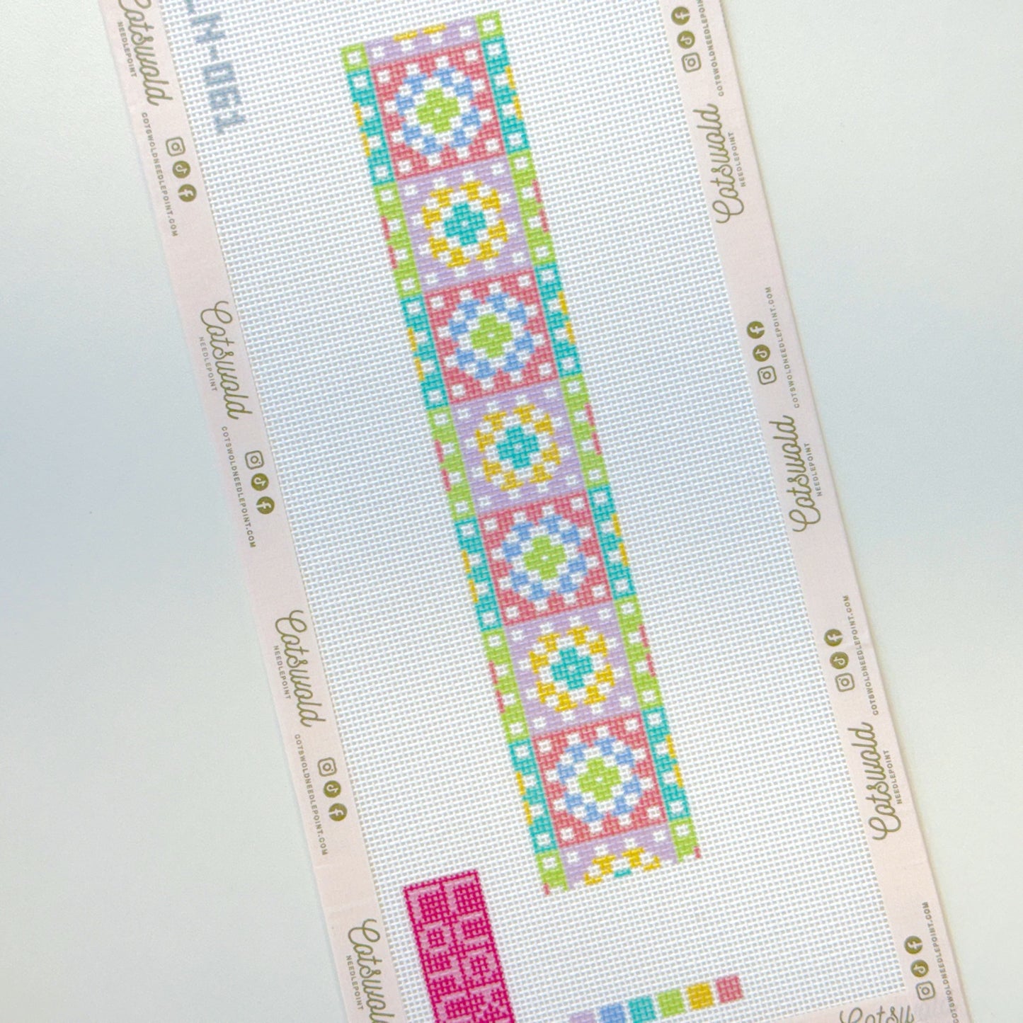 Pastel geometric needlepoint canvas strip styled flat lay on 18 mesh