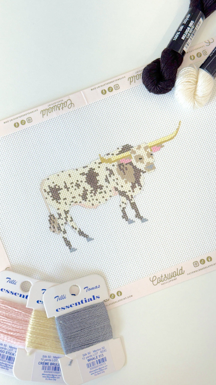 Angled view of Texas longhorn cow needlepoint canvas with cream black and gray fibers